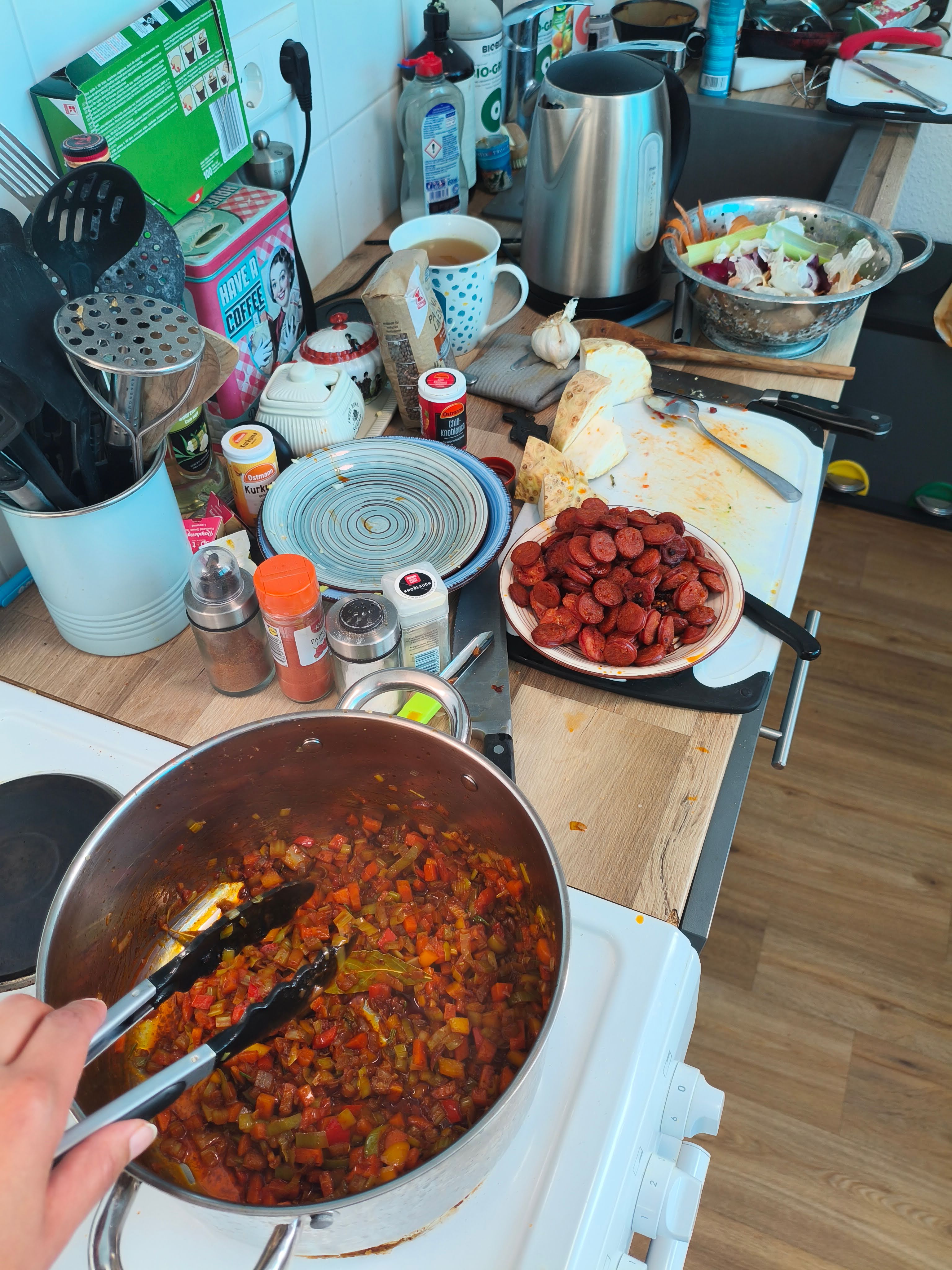 Berlin kitchen mid-cook — cutting boards, diced vegetables, and spice jars spread across the counter during lentejas preparation